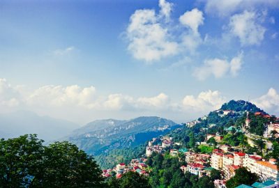 Picturesque view of Shimla's mountains and townscape under a clear blue sky.