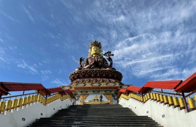 Majestic Maitreya Buddha statue under a clear blue sky in Pelling, Sikkim.