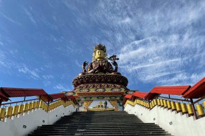 Majestic Maitreya Buddha statue under a clear blue sky in Pelling, Sikkim.