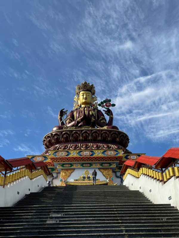 Majestic Maitreya Buddha statue under a clear blue sky in Pelling, Sikkim.