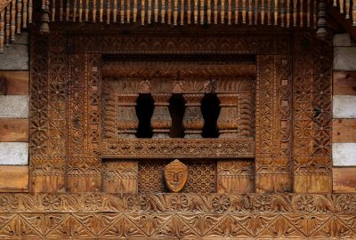 Detailed wooden carving on a traditional Indian temple facade, showcasing ancient architecture.