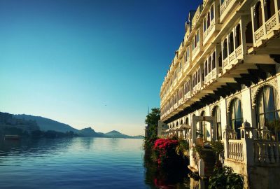 Stunning view of a lakeside palace in Udaipur, reflecting its intricate architecture on the serene water.