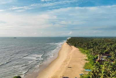 A breathtaking aerial shot of Malpe Beach in Udupi, showcasing pristine sands and turquoise waters.