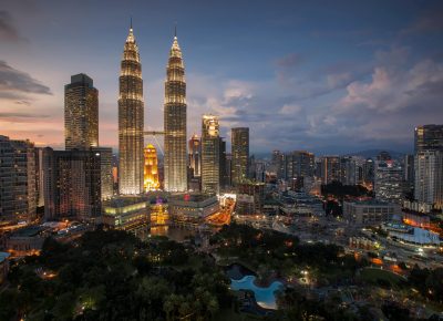 Stunning Kuala Lumpur skyline featuring the illuminated Petronas Towers at twilight.
